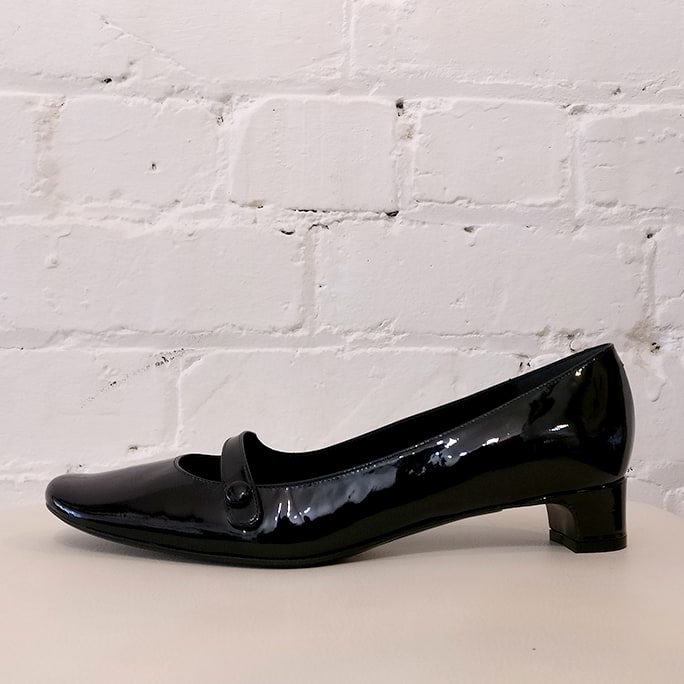 Patent leather mid-heel shoe with strap.