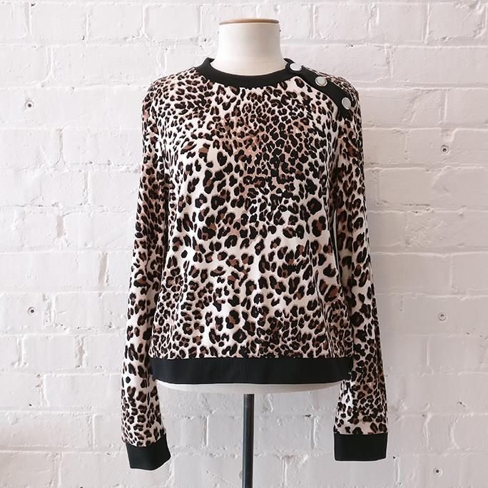 Animal print crew top with shoulder button detail.