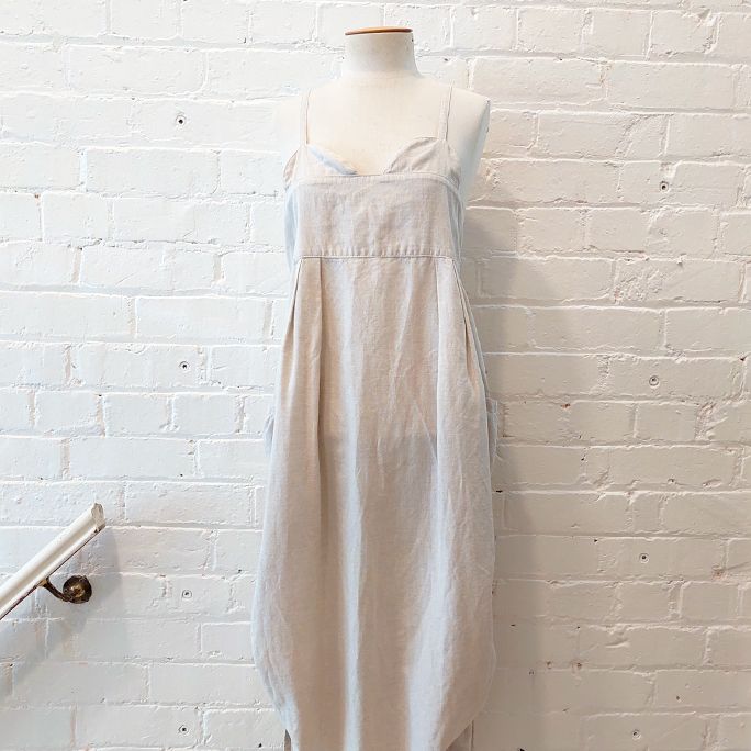 Oversize strappy dress with patch pockets and gathered sides.