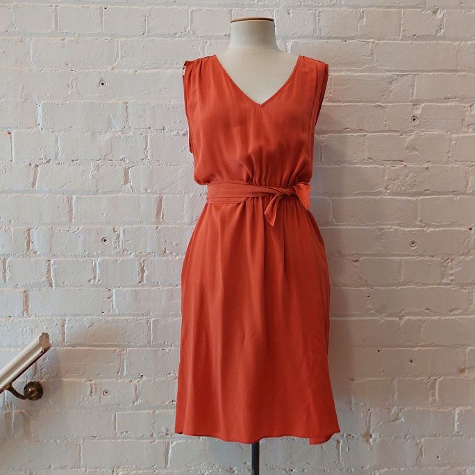 Sleeveless silk shift dress with pockets and fabric sash.