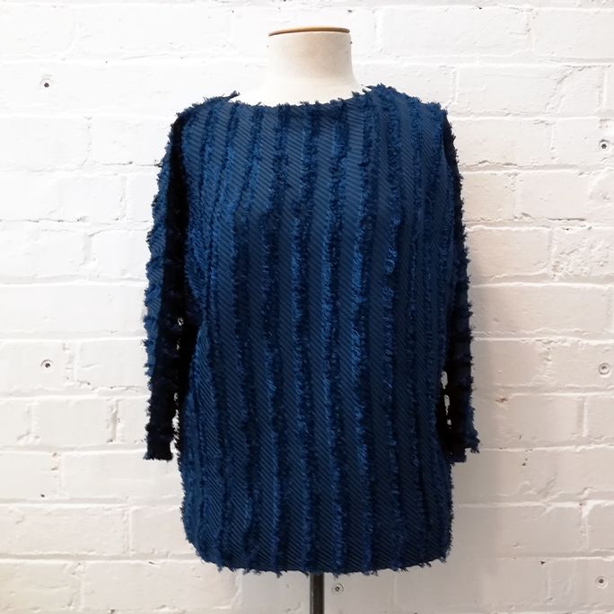 Bat sleeve top with fringe detailing.