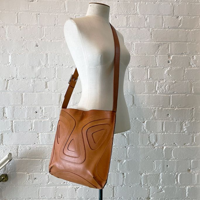 Fully lined leather satchel with cut-out relief.