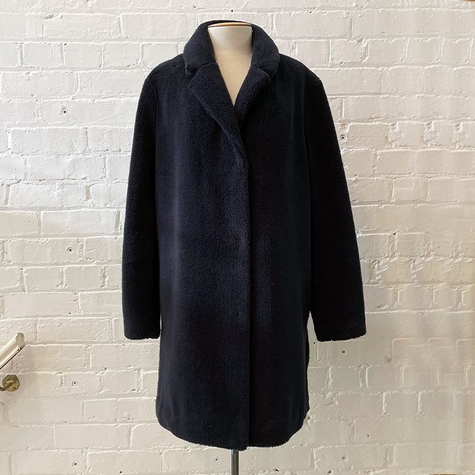Faux fur coat with dome fasteners and pockets, fully lined.