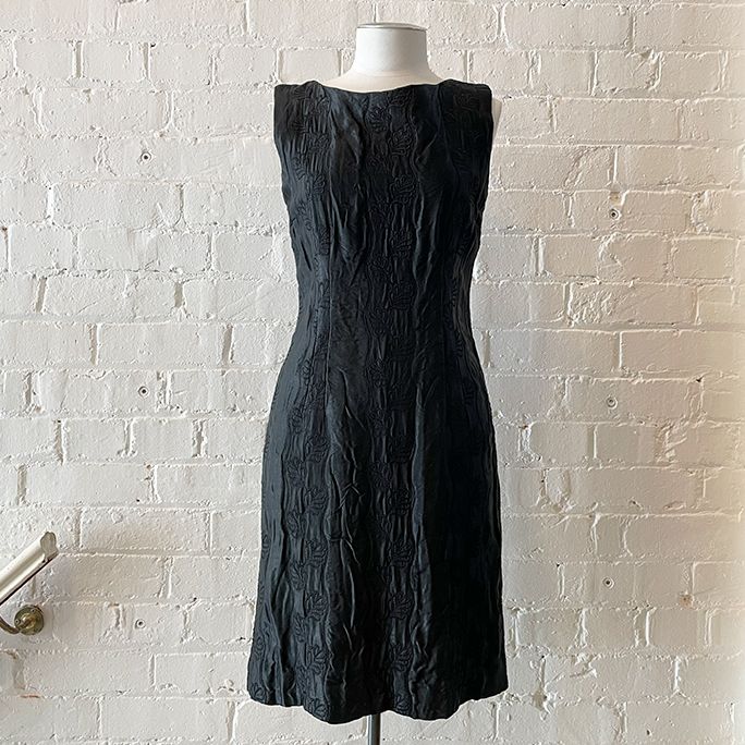 Sleeveless quilted shift dress with embroidered floral motif, fully lined.